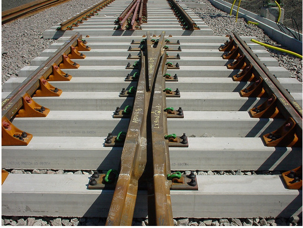 (b) Cast manganese crossing installed in track.