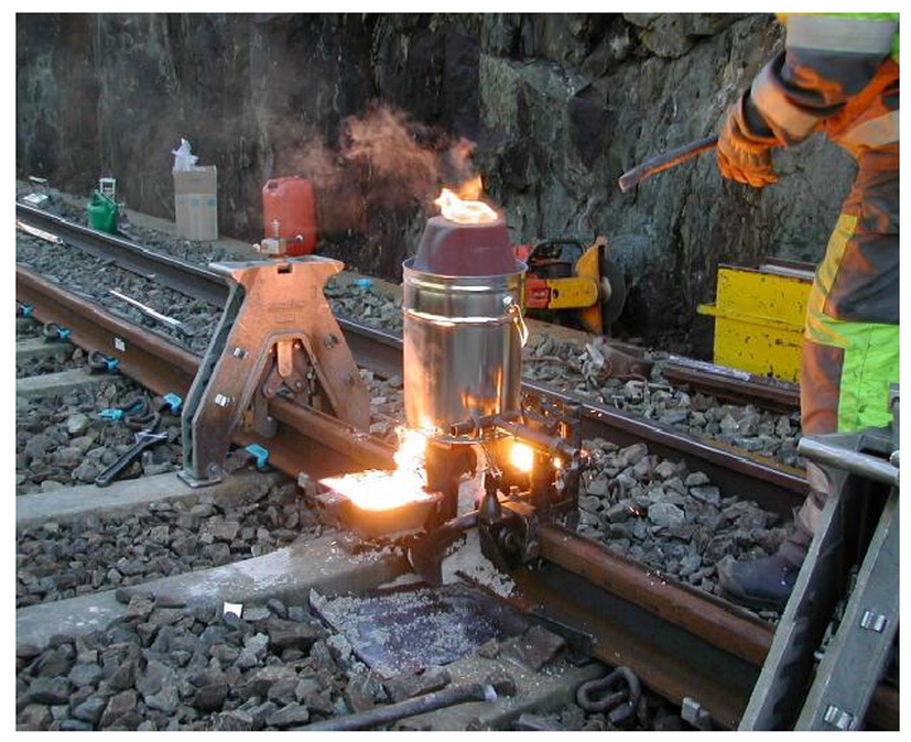 (a) Thermite weld being made in track